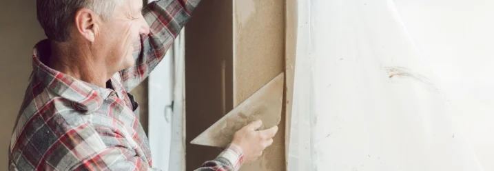 Person verputzt Wand mit Kelle